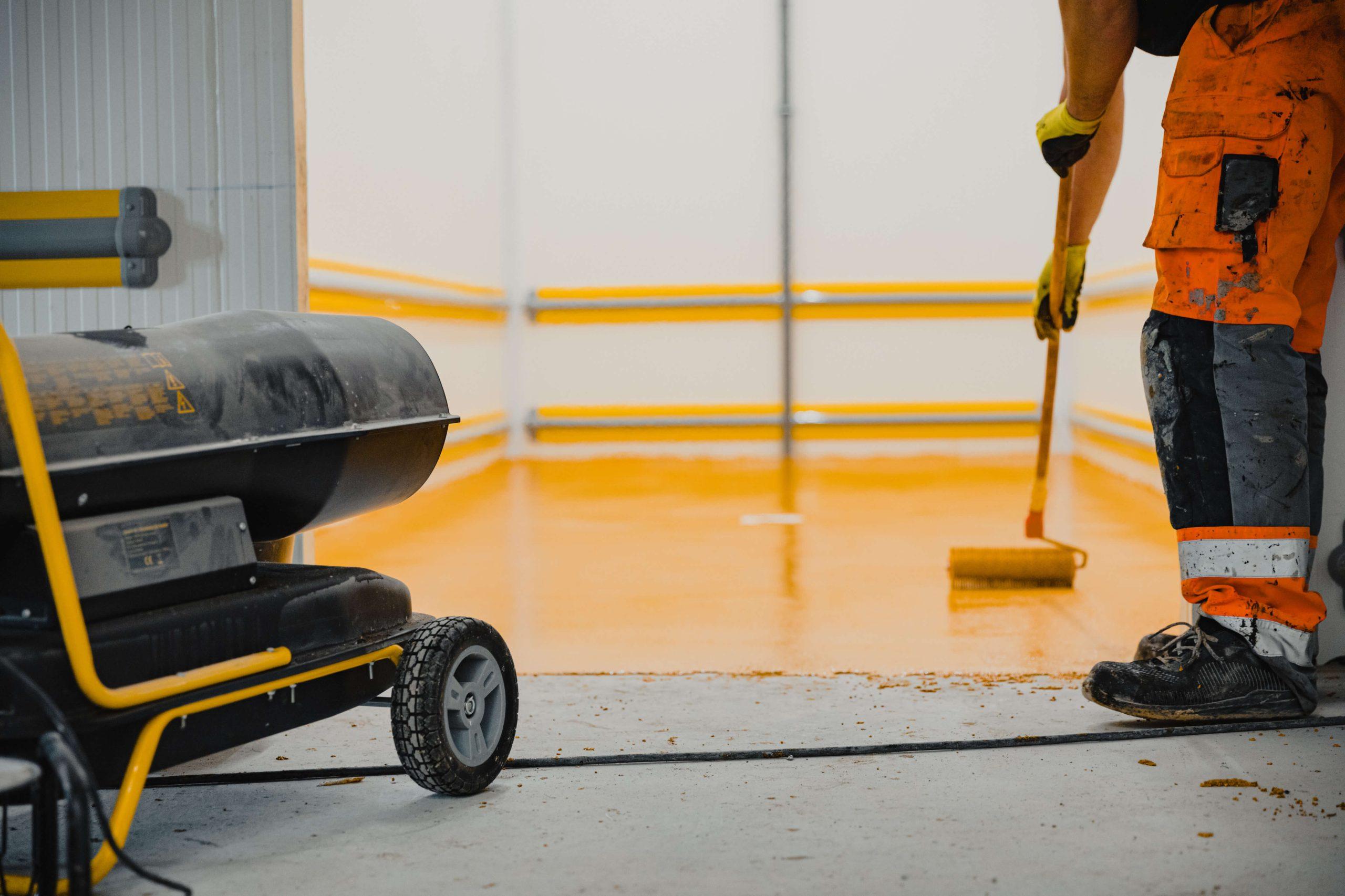 Painter applies epoxy flooring coatings