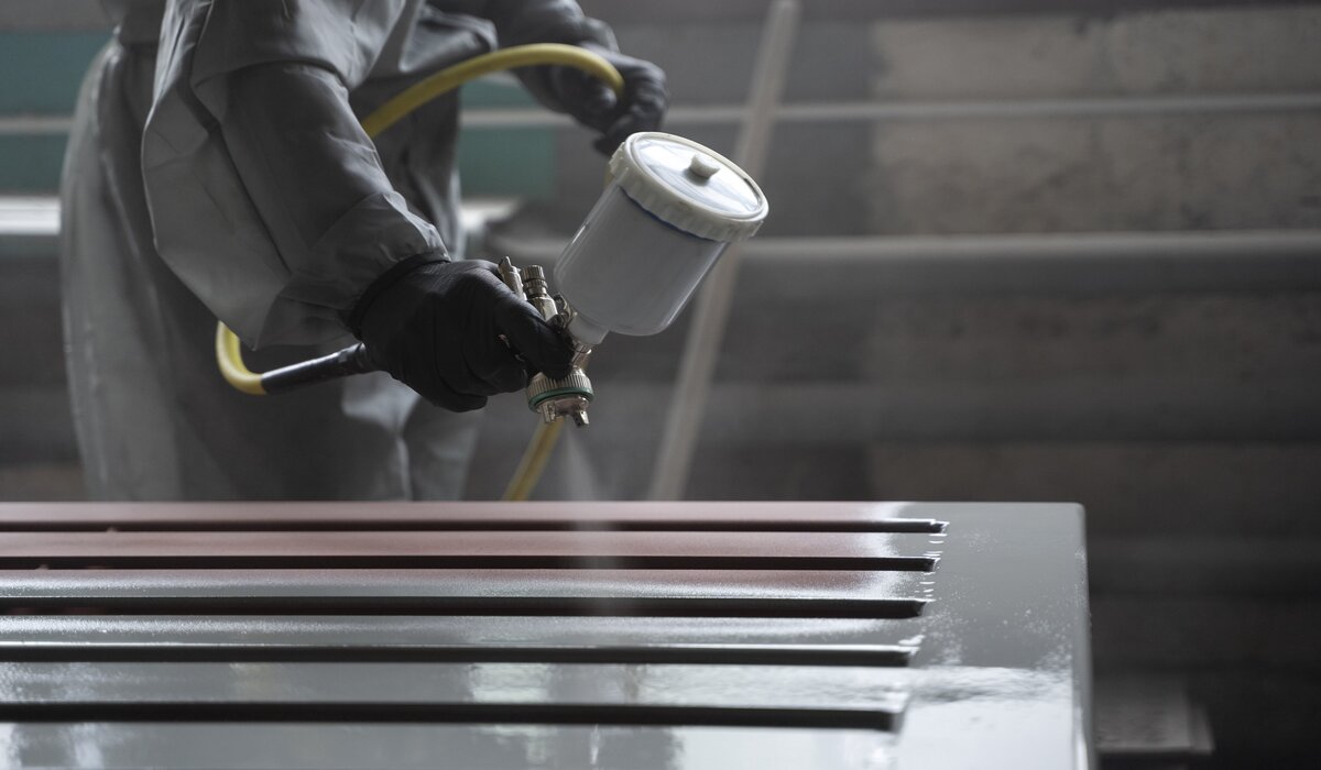 painter spraying powder paint from gun