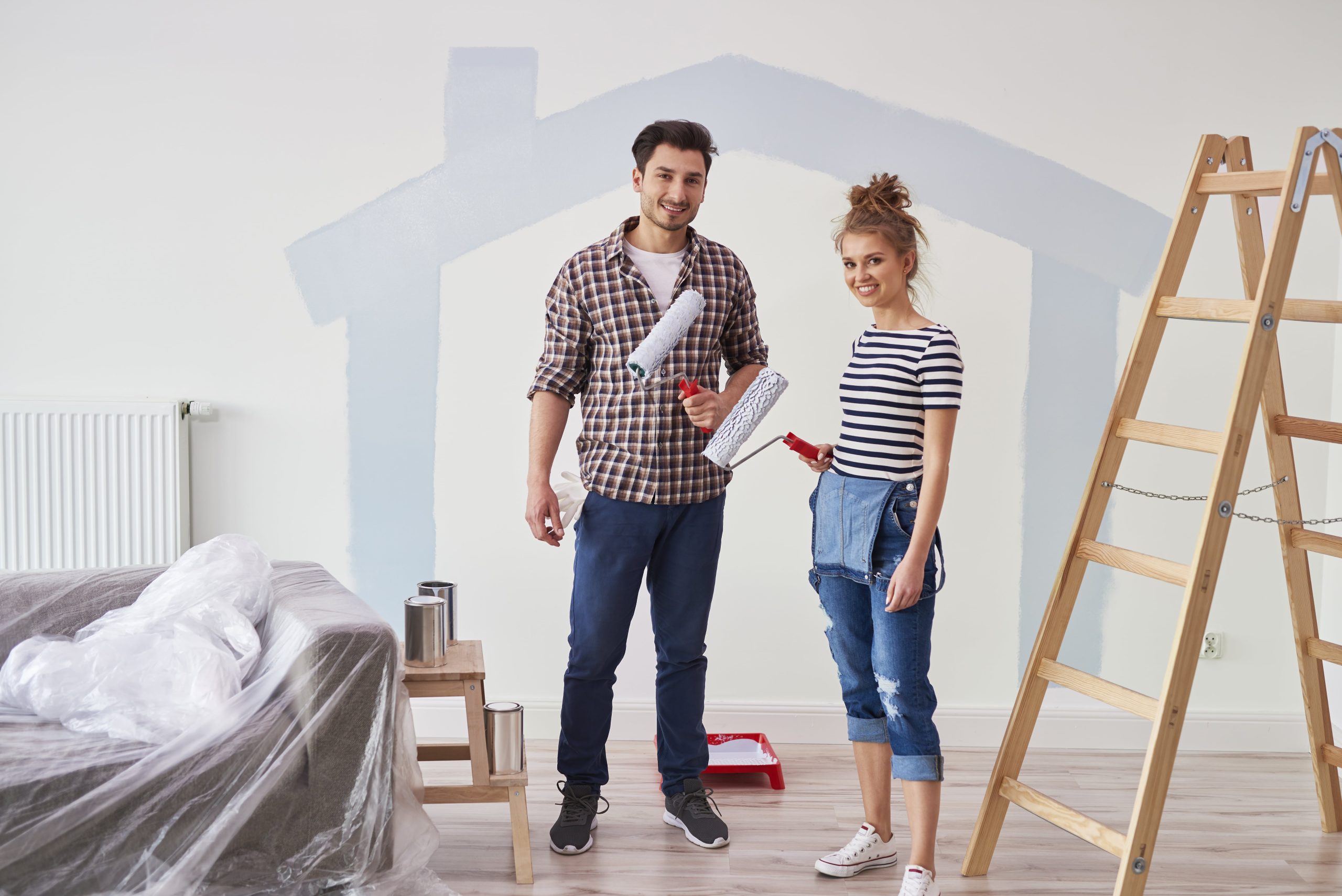 couple painting interior wall new apartment