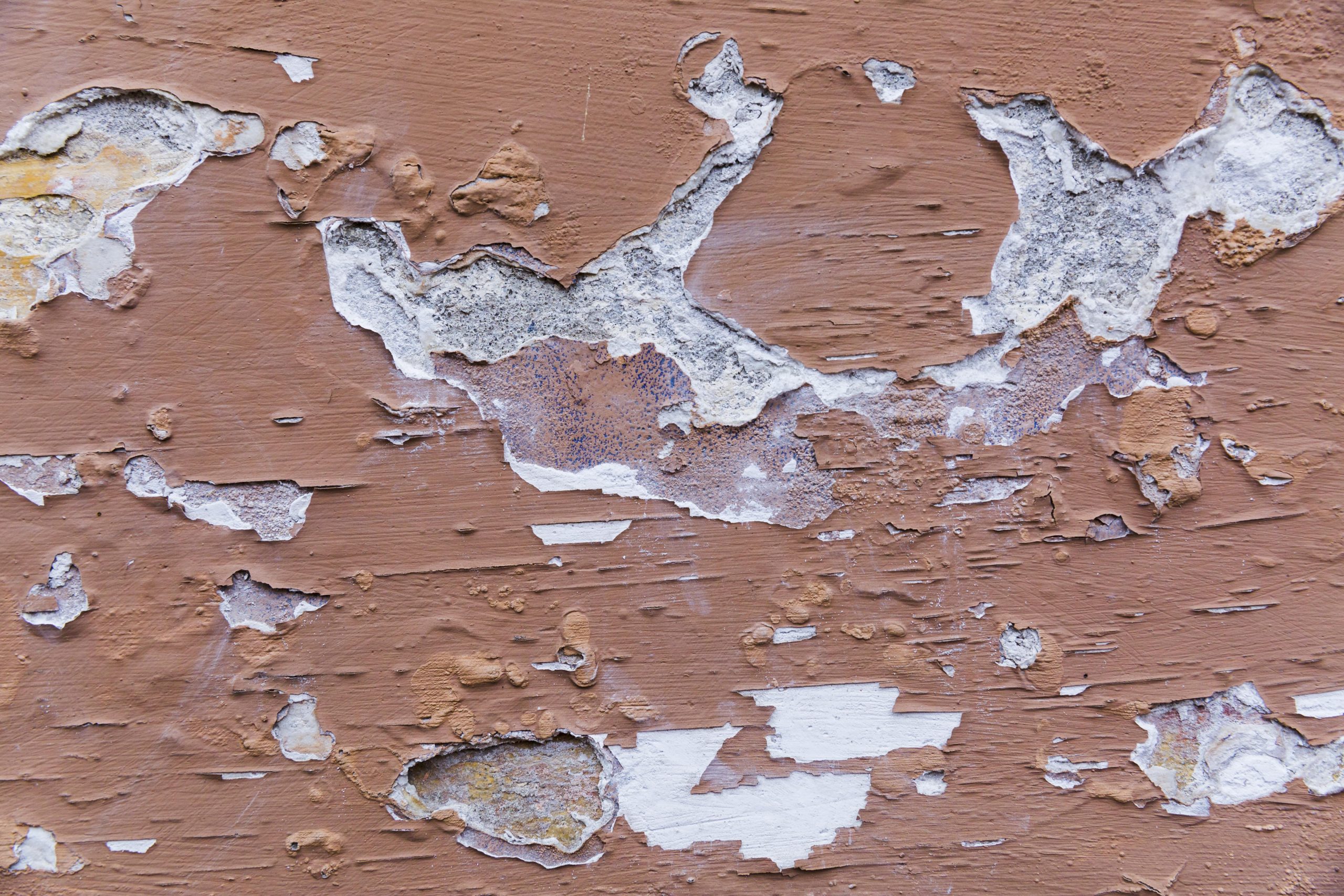 paint peeling off rough concrete wall