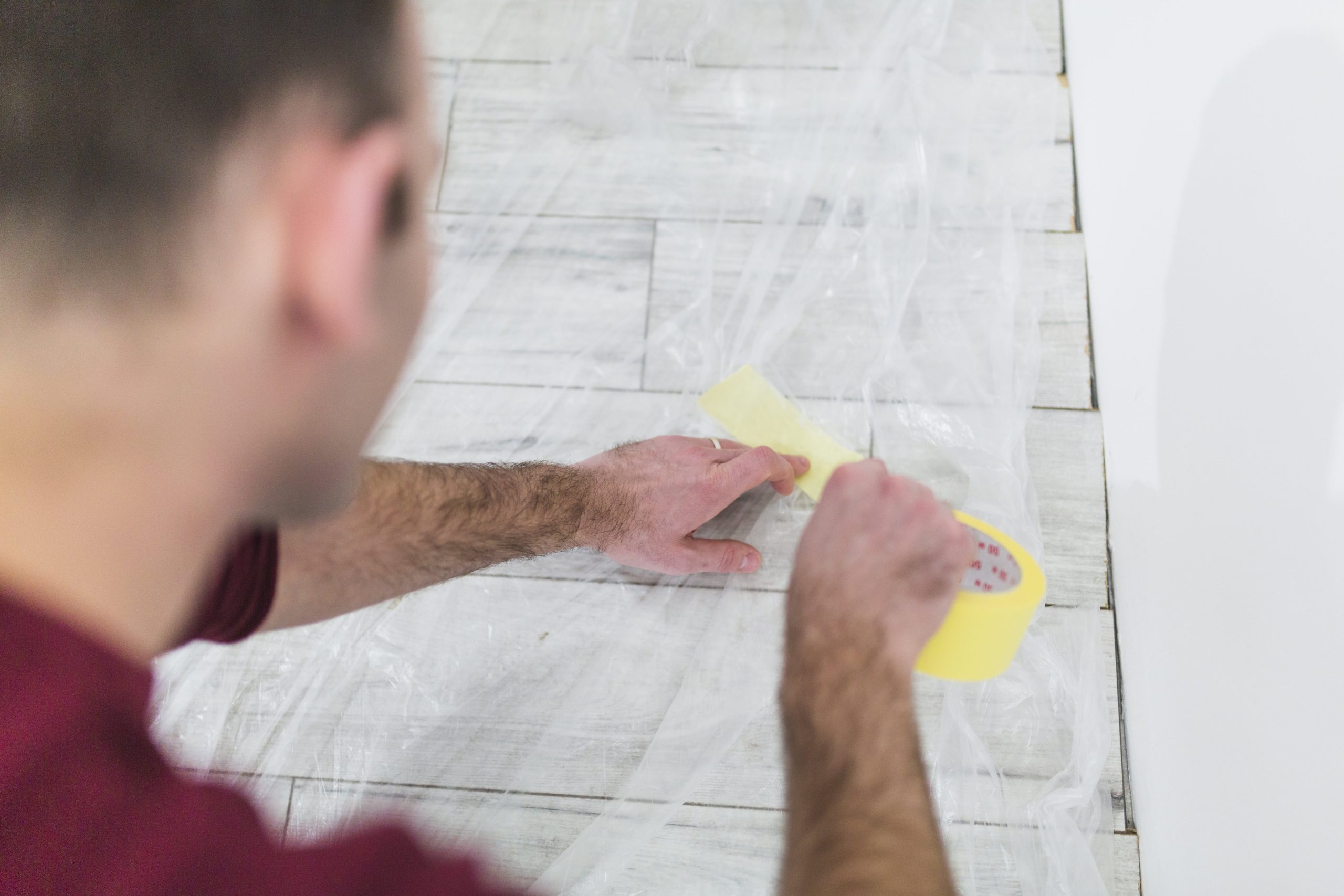 man protecting floor with sheet