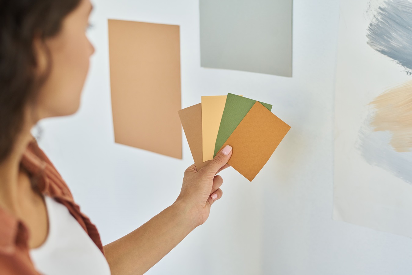 woman with palette of colour swatches choosing one for walls